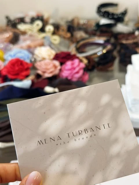 Tarjeta de Mena Turbante frente a la colección de accesorios de la marca